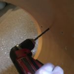 Drilling the hardware holes through the new wrap.